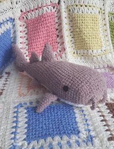 a crocheted blanket with a stuffed shark on it