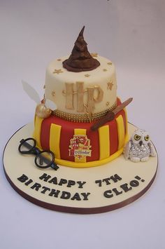 a birthday cake with an owl and harry potter hat on it's top tier