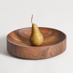 a wooden plate with a pear on it