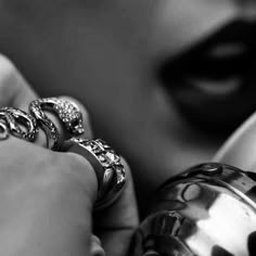 a close up of a person's hand holding an open teapot with rings on it