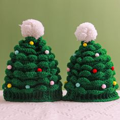 two crocheted christmas trees sitting on top of a table