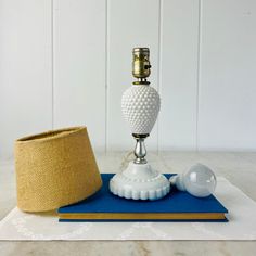 a white lamp sitting on top of a table next to a blue mat and light bulb