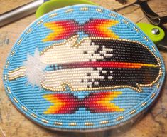 beaded feather barrette white buckskin backing and large metal barrette. Indigenous Beadwork, Beaded Hair Ties Regalia, Native American Beadwork Patterns Hair Barrettes, Native American Beaded Headband Regalia, Native Beaded Barrettes, Alaska Native Beadwork