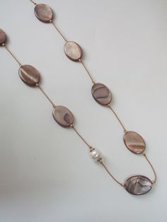 Long necklace in iridescent light beige mother-of-pearl and white freshwater pearl. Timeless and elegant, this long necklace is made from brown silk thread on which oval mother-of-pearl pebbles run. Iridescent with reflections, they are combined with pretty, slightly irregular white cultured pearls. The length of this necklace can be customised (choice from the drop-down menu or personalised request) and a 5 cm extension chain (in gold-plated 925 silver) can be added on request (choice from the drop-down menu). For example, the model shown measures 80 cms. ** Materials **  Mother-of-pearl pucks. White freshwater pearls. Silk thread. ** Shipping ** Gift wrapping with personalised note available on request. Tracked delivery is free of charge. ** To take good care of your accessories, I advis Iridescent Light, Personalized Gift Wrap, Brown Silk, White Freshwater Pearl, Silk Thread, Chain Ring, Natural Pearls, Cultured Pearls, Light Beige