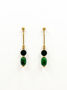 These earrings are a refined blend of natural stone and metal, ideal for someone who appreciates minimalist jewelry. The linear design incorporates distinct contrasting shapes creating a sleek and modern aesthetic.  Each earring features a geometric design with a combination of brass, matte onyx, and polished green chalcedony semi precious stones. The smooth, warm golden tone of the brass contrasts with the subtle texture of the matte black onyx coin shaped stone.  Barrel shaped chalcedony stone Green Minimalist Brass Earrings, Minimalist Green Brass Earrings, Minimalist Natural Stone Earrings, Set Theory, Chalcedony Earrings, Chalcedony Stone, Linear Design, Green Chalcedony, Gold Dangle Earrings