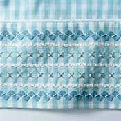 a blue and white checkered table cloth with an intricate design on the edges,