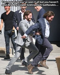 two men in suits are pulling another man's back