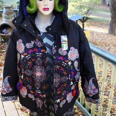 A Beautiful Boho Style Winter Ladies Jacket. Zippered Removable Hood. The Maker Is Desigual. Tag States Padded Emotion. There Are All Types Of Designs On The Jacket . Front, Back, Sleeves. Believe A Medalion Of Some Sort. Lots Of Paisley Or Swirls. Front Pockets Are Slant With Zipper For Closure. There Are Tassels On The End Of The Zippers. The Color Is Black. The Other Colors Are Many Including Some Not All: White, Red, Pink, Blue Green. The Sleeve Cuffs Are Embroidered. The Size On Label Of Ja Bohemian Hooded Spring Outerwear, Bohemian Hooded Outerwear For Spring, Hooded Embroidered Fall Outerwear, Hooded Multicolor Winter Outerwear, Casual Embroidered Outerwear For Outdoor, Black Bohemian Outerwear For Outdoor, Multicolor Winter Outerwear With Adjustable Hood, Winter Embroidered Hooded Outerwear, Black Embroidered Winter Outerwear