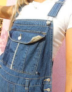 Original vintage blue denim short dungarees with contrasting stitching. Front pocket. Front and back waist pockets. Belt loops. Adjustable straps. Size large, UK 14-18 / Eur 42-46. Measurements - 10"(26cm) top bib width - 10"(26cm) bib height - 36"(92cm) waist - 44"(112cm) hips - 16"(41cm) outer leg. Material - Denim. Condition - Good, small repair to back near pocket, reflected in our price. Handpicked, repaired and ready to wear. This is an original vintage item, not new and minor signs of wear & age are expected, we will highlight any major flaws. Model is a size 8 and is 5'6" tall. Dark Wash Denim Shortalls With Pockets, Denim Shortalls With Pockets In Dark Wash, Denim Shortalls With Pockets And Bib Front, Denim Blue Bib Front Shortalls With Pockets, Medium Wash Shortalls With Bib Front And Pockets, Utility Denim Shortalls With Side Pockets, Dark Wash Bib Front Shortalls With Pockets, Utility Dark Wash Shortalls With Pockets, Utility Style Dark Wash Shortalls With Pockets