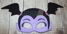 a purple mask with black wings on it