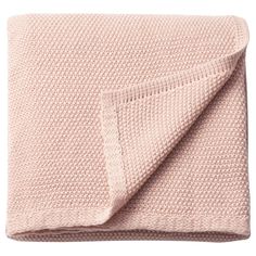 a pink blanket folded on top of a bed