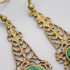 Long filigree earrings are a soft aged brass and have a green black glass stone at the bottom. These are so pretty and lightweight. The contrast of the brass and green is really nice. The earwires were missing so I did replace them. They are unmarked and in excellent condition. The drops alone measure 1 3/4 inch and from the top of the earwire to the bottom of the drop they are 2 1/4 inch. The kind of earring you find yourself reaching for all the time. Cute, dangly and comfortable. Find lots mo Vintage Green Brass Earrings, Antique Brass Chandelier Earrings For Gift, Antique Brass Chandelier Earrings As Gift, Antique Brass Drop Plug Earrings, Antique Brass Plug Drop Earrings, Vintage Bronze Chandelier Earrings In Brass, Vintage Brass Filigree Chandelier Earrings, Vintage Bronze Brass Chandelier Earrings, Brass Filigree Drop Plug Earrings