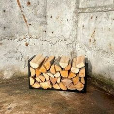 a pile of wood sitting in front of a cement wall