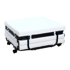 an image of a white mattress with wheels on the bottom and black straps attached to it