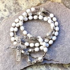 "This one of a kind small handmade catholic rosary would make a great first communion gift. The Ave beads are 5mm luster white faceted glass beads. The Pater beads are 6mm oxidized silver roses. The 14mm ( 5/8\") oxidized silver center shows a communion chalice with host. Double sided. The 30mm ( 1.25\" ) oxidized silver cross has the Good Shepherd. Total length of the rosary: 12.5\", 31cm Circumference of the upper part: 13\" (42cm) All my rosaries and jewelry are guaranteed one of a kind, whic Small Rosary, White Rosary, Good Shepherd, First Communion Gifts, Catholic Rosary, Catholic Jewelry, Communion Gifts, The Good Shepherd, Rosary Catholic