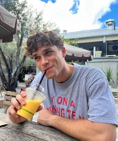 a man sitting at a table with a drink in his hand