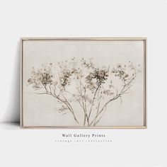 an art print with flowers in it on a white wall next to a wooden frame