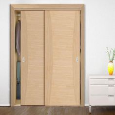 an open closet door in a white room with wooden flooring and drawers on either side