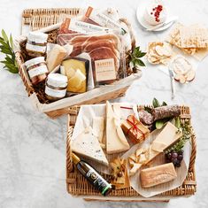 two wicker baskets filled with cheeses and crackers on top of a table