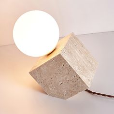 a light that is sitting on top of a block of concrete with a cord in front of it