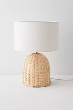 a wicker lamp with a white shade