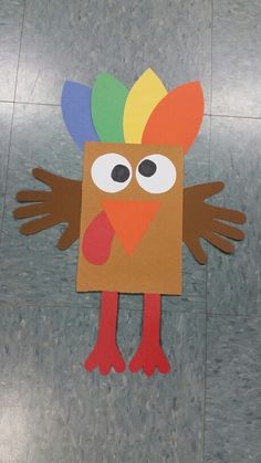 a paper cut out of a turkey with colored feathers on it's head and eyes