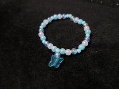 A handmade blue and white beaded bracelet with a butterfly charm One size fits all. Made with Elastic crystal beading core. White Beaded Bracelet, Bracelet Blue, Bracelets Handmade Beaded, Butterfly Charm, Blue Bracelet, A Butterfly, Beaded Bracelet, One Size Fits All, Halloween Shopping