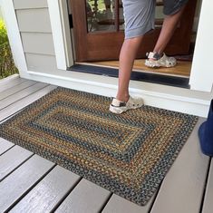 a person stepping into a door with their feet on the mat in front of them