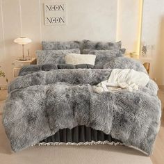 the bed is made with grey fur and pillows