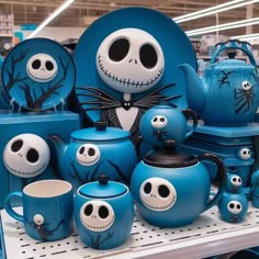 a display in a store filled with blue and white halloween themed pots, mugs and saucers