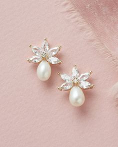 NAOMI FRESHWATER PEARL STUD EARRINGS (JE-4153) Perfectly floral with a dainty pearl accent, our Naomi Freshwater Pearl Studs are perfect for brides & bridesmaids. DETAILS * Crafted with cubic zirconias & freshwater pearls. * Measures .75 inches long. * Finishes: silver & gold. * Model is wearing silver. SHOP MORE STYLES https://www.etsy.com/shop/darethcolburndesigns HELP & ADVICE Styling questions or need help finding the right accessory? Please message me at any time -- I'm alwa Wedding Earrings Silver, Bridal Earrings Silver, Pearl Wedding Earrings, Pearl Bridal Earrings, Bridal Jewels, Wedding Studs, Pearl Earrings Wedding, Bridal Earrings Pearl, Pearl Bridal