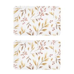 two placemats with leaves and berries on them, one in gold and the other in white