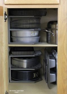 an open cabinet filled with dishes and pans