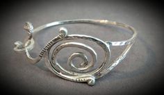 Customized in size, this Sterling Silver bracelet has been handcrafted with a swirl design, making a great addition to everyone's jewelry box. Elegant Spiral Sterling Silver Bracelets, Elegant Spiral Bracelet As Gift, Elegant Spiral Bracelet For Gift, Elegant Sterling Silver Spiral Bracelet For Gift, Modern Twist Swirl Jewelry As Gift, Modern Twist Swirl Jewelry For Gift, Silver Spiral Cuff Bracelet Gift, Handmade Swirl Jewelry With A Modern Twist, Elegant Spiral Cuff Bracelet As Gift