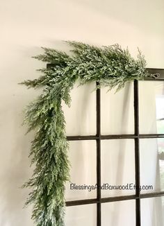 a window frame is decorated with greenery