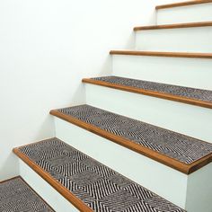 the stairs are decorated with black and white designs on them as well as wooden handrails