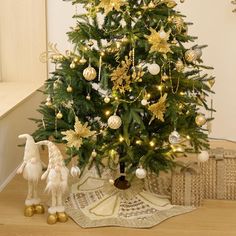 a small christmas tree with gold and white ornaments