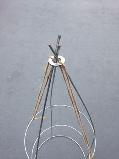 an upside down metal object on the ground with wires attached to it's sides