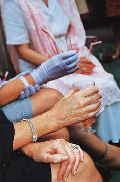 two women sitting on a bench holding wine glasses