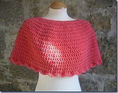 a pink crocheted shawl on a mannequin