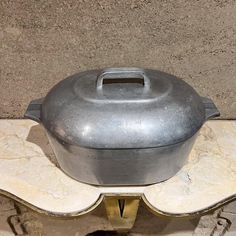 a metal pot sitting on top of a stone slab