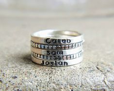 "Skinny sterling silver rings are just the right width to hold a name, a word, or a thought as a reminder on your finger. Because they are so narrow you can easily stack them with other words or names or with any decorative rings. This listing is for ONE 2mm stamped ring. I have both upper and lowercase letters and numbers in this simple font. Make sure you include your text in the box at check out exactly as you would like it to appear on the ring. These are all hand stamped which adds to their Customizable Silver Rings For Everyday, Sterling Silver Name Rings For Birthday, Sterling Silver Rings With Names For Birthday, Minimalist Silver Rings With Names, Personalized Name Sterling Silver Stackable Rings, Anniversary Sterling Silver Stackable Name Rings, Customizable Sterling Silver Stackable Rings For Everyday, Adjustable Sterling Silver Rings With Names, Anniversary Sterling Silver Stackable Rings With Names