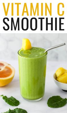 a green smoothie with oranges and mint on the side