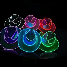 several neon hats sitting on top of each other in front of a black background,