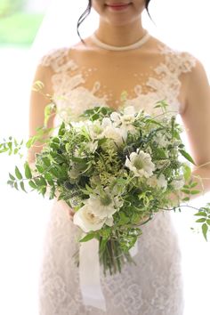 a bride holding a bouquet of flowers in her hands