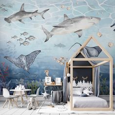 a child's bedroom decorated in blue and white with sharks on the wall, shark bedspread, fish bedding