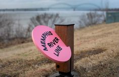 a pink frisbee that is stuck to a wooden post with the words meraphus river live on it