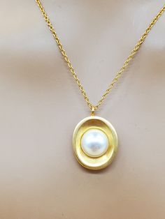 In good used vintage condition.  Clearly stamped.  Gold tone metal with faux pearl.  Please look at the pictures for details and condition because the exact item pictured is the exact item that you will receive. Gold Oval Pearl Necklace With Pearl Charm, Oval Gold Pearl Necklace With Pearl Charm, Gold Oval Pendant Pearl Necklace, Elegant Gold-colored Brass Pearl Necklace, Gold Pearl Necklace With Large Pendant, Oval Gold Pearl Necklaces, Gold Pearl Necklace With Oval Shape, Gold Brass Necklaces With Pearl Pendant, Gold Brass Necklace With Pearl Pendant