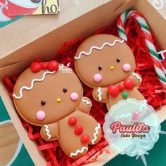 two decorated gingerbreads in a box on a table