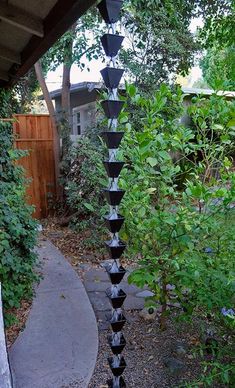 a very tall black and white tower in the middle of a garden